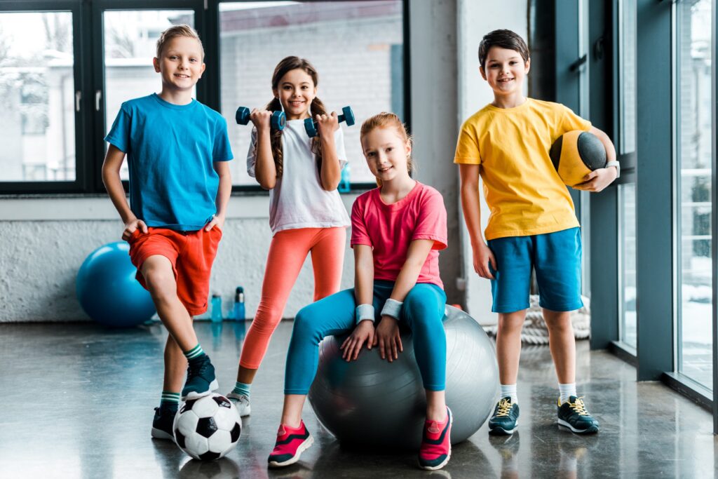 Laughing,Preteen,Kids,Posing,With,Sport,Equipment